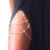 A sparkling gold and crystal leg chain displayed elegantly on a thigh, showcasing its adjustable design and shimmering details perfect for festive or glamorous events. 