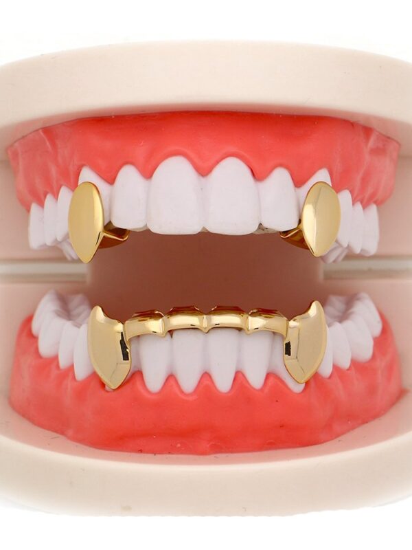 Close-up image of a 14K gold-plated vampire fang grillz set with a shiny finish, displayed alongside adjustable silicone molding bars and a storage case. 